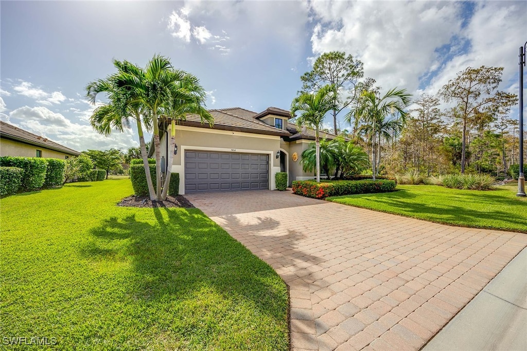 mediterranean / spanish house with a front yard and a garage