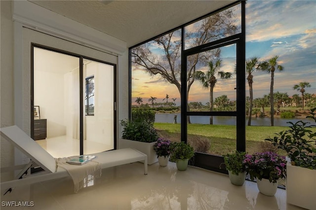 sunroom / solarium featuring a water view