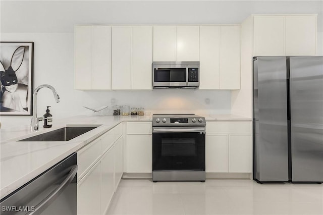 kitchen with white cabinets, light tile patterned flooring, sink, and appliances with stainless steel finishes