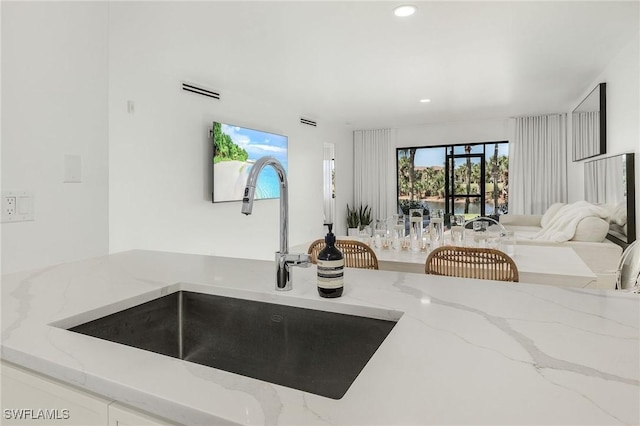 kitchen featuring light stone countertops and sink