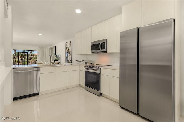 kitchen featuring light countertops, recessed lighting, white cabinets, stainless steel appliances, and modern cabinets