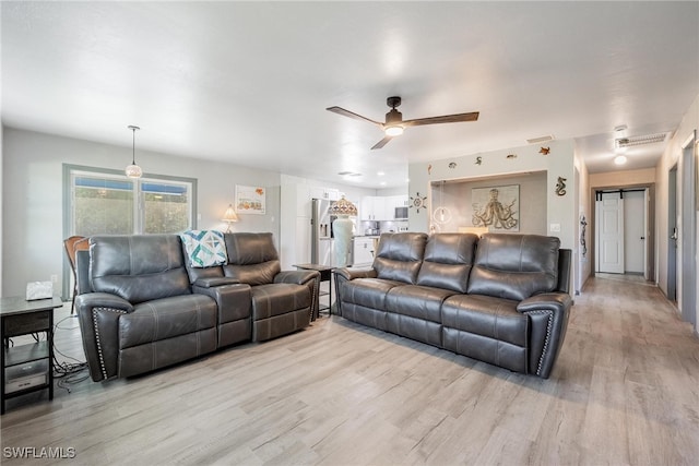 living room with ceiling fan and light hardwood / wood-style flooring