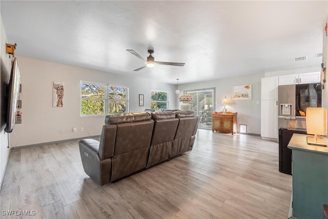 living room featuring ceiling fan and light hardwood / wood-style flooring