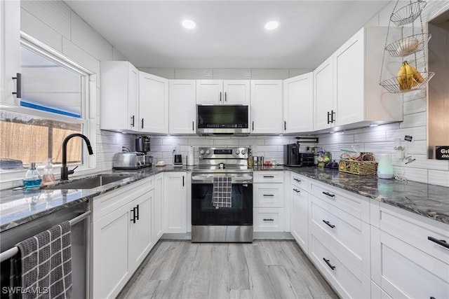 kitchen with dark stone countertops, sink, white cabinetry, and stainless steel appliances