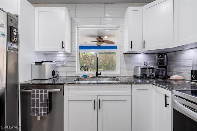 kitchen featuring white cabinets, dark stone countertops, sink, and appliances with stainless steel finishes