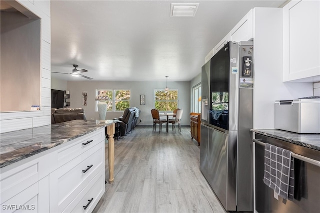 kitchen with white cabinetry, stainless steel fridge, ceiling fan, and light hardwood / wood-style floors