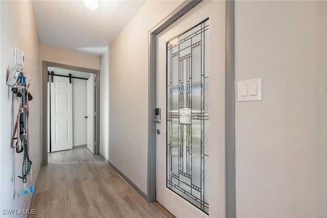 doorway featuring a barn door and light wood-type flooring