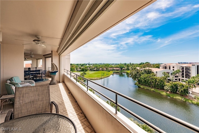 balcony with ceiling fan and a water view