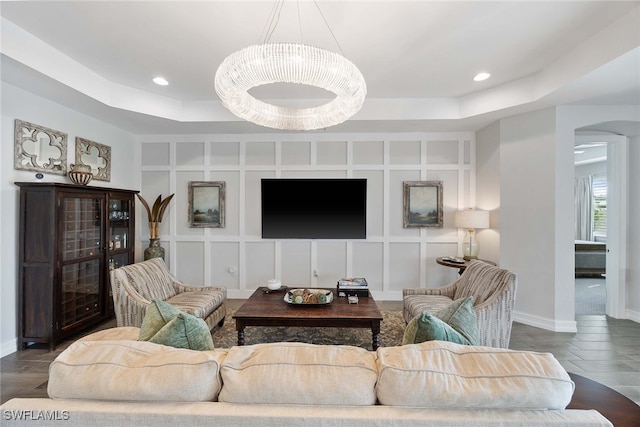 living room featuring wood-type flooring and a raised ceiling