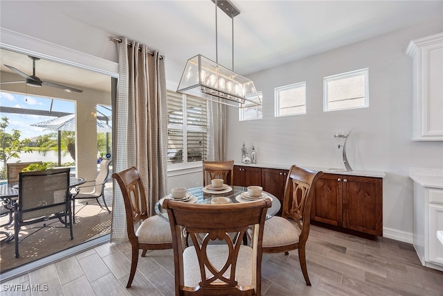 dining area with light hardwood / wood-style flooring and ceiling fan with notable chandelier