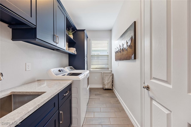 washroom with cabinets, independent washer and dryer, light hardwood / wood-style flooring, and sink