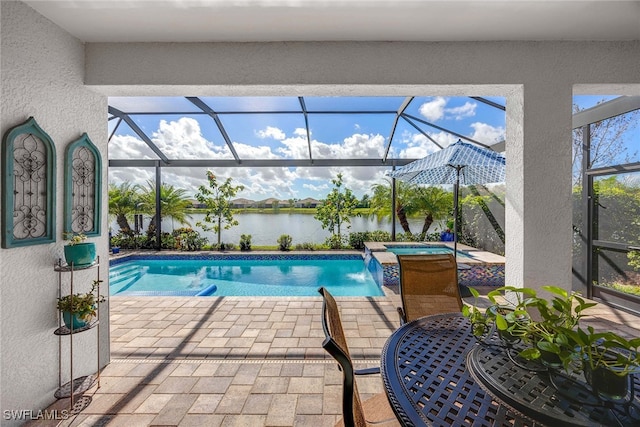 view of pool featuring pool water feature, glass enclosure, a patio area, and a water view