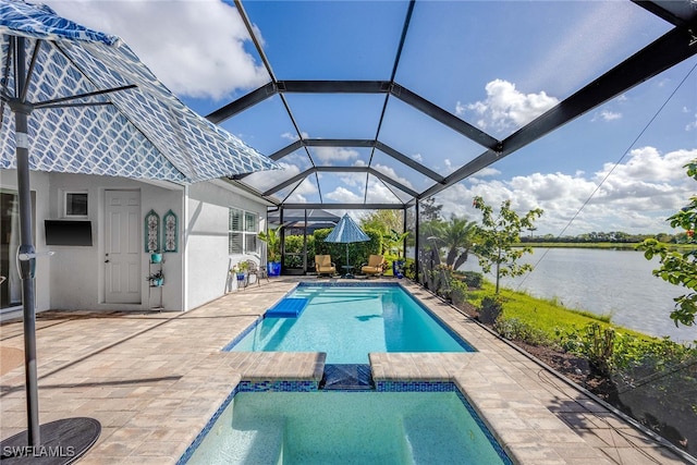 view of pool with glass enclosure, a patio area, and a water view