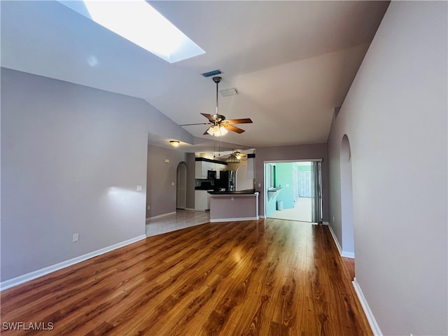 unfurnished living room featuring wood-type flooring, ceiling fan, and vaulted ceiling