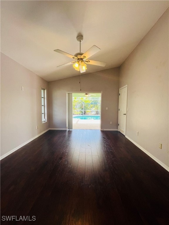 spare room with dark hardwood / wood-style flooring, vaulted ceiling, and ceiling fan