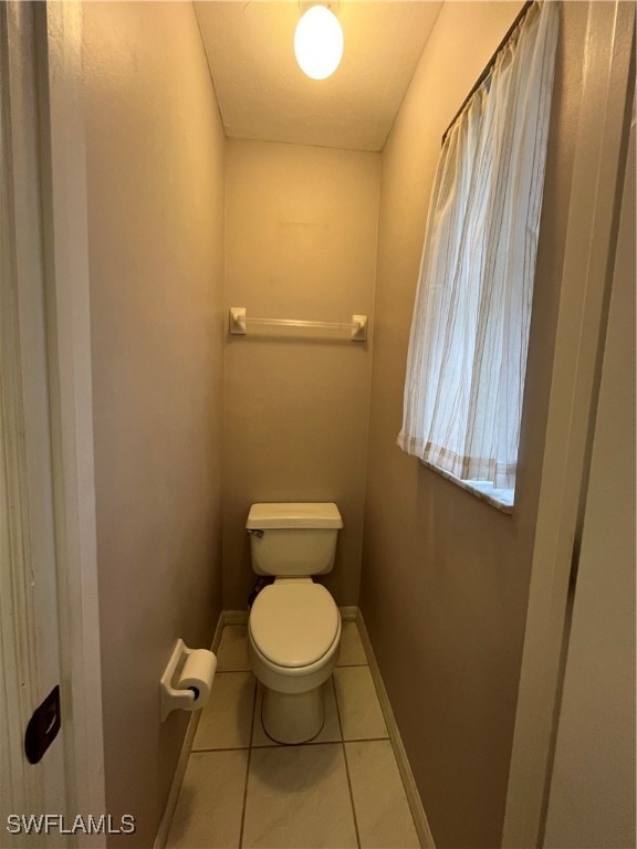 bathroom with toilet and tile patterned floors