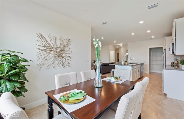 dining area featuring sink and light tile patterned flooring