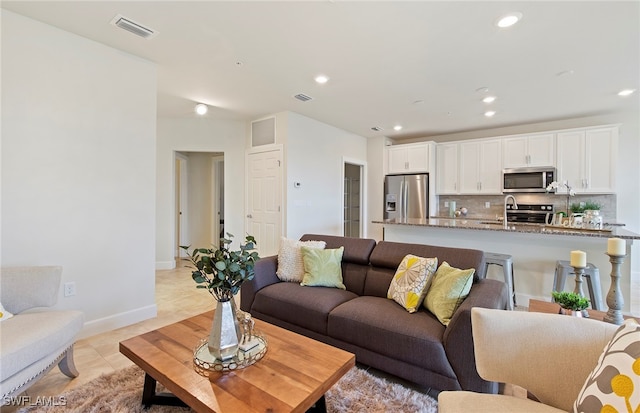 living room featuring light tile patterned floors and sink