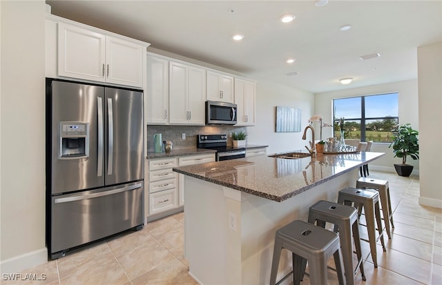 kitchen with white cabinets, sink, a kitchen island with sink, and appliances with stainless steel finishes