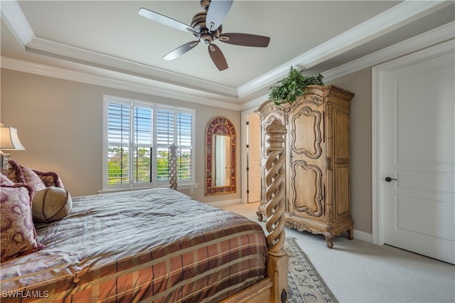 bedroom with a raised ceiling, ceiling fan, crown molding, and light carpet