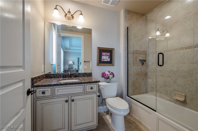 full bathroom with tile patterned flooring, vanity, toilet, and enclosed tub / shower combo