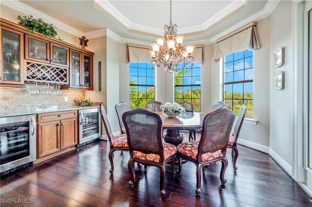 2555 Marquesa Royale Ln Unit 1-301, Naples, FL 34109 - dining room with wine cooler, crown molding, a chandelier, a tray ceiling, and dark wood-type flooring