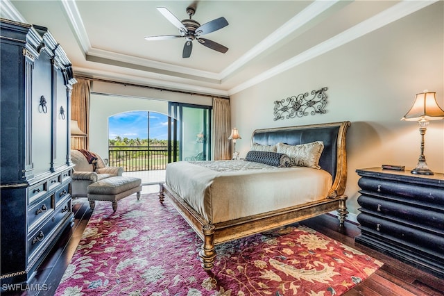 bedroom featuring ceiling fan, a raised ceiling, dark hardwood / wood-style flooring, crown molding, and access to outside