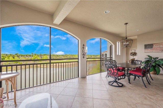 2555 Marquesa Royale Ln Unit 1-301, Naples, FL 34109 - sunroom / solarium featuring a chandelier, a water view, and beam ceiling