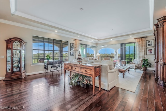 living room with a wealth of natural light, dark hardwood / wood-style floors, and ornamental molding