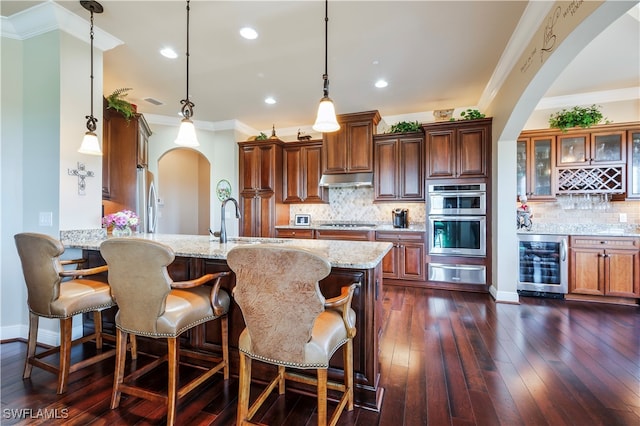 kitchen featuring tasteful backsplash, wine cooler, dark hardwood / wood-style flooring, pendant lighting, and appliances with stainless steel finishes