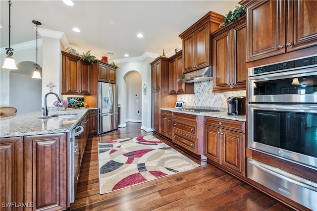 kitchen with ornamental molding, stainless steel appliances, sink, dark hardwood / wood-style floors, and hanging light fixtures