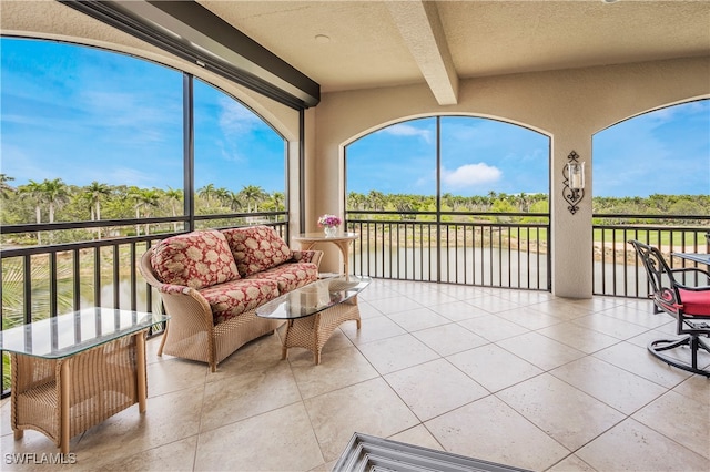 sunroom with vaulted ceiling with beams and a healthy amount of sunlight