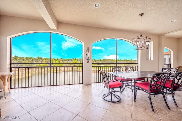 2555 Marquesa Royale Ln Unit 1-301, Naples, FL 34109 - tiled dining area with a textured ceiling, a water view, a chandelier, healthy amount of natural light, and recessed lighting