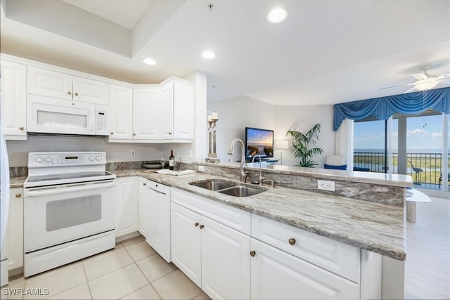 kitchen featuring white appliances, sink, light tile patterned floors, white cabinetry, and kitchen peninsula