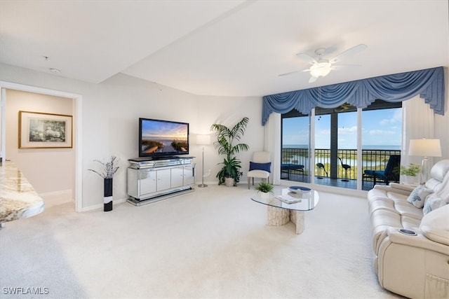 carpeted living room with ceiling fan