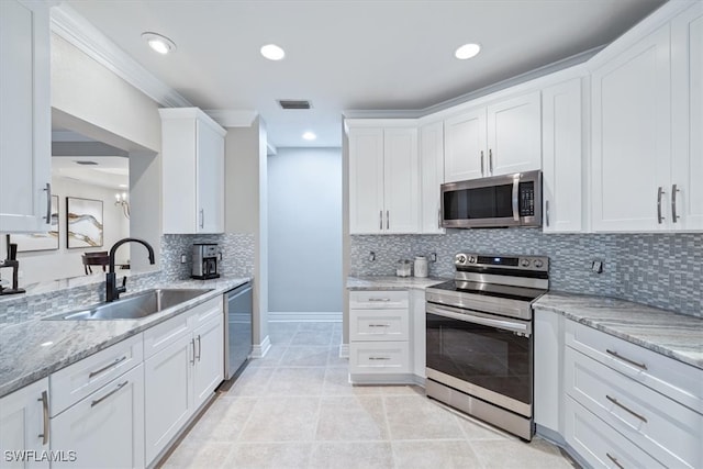 kitchen with decorative backsplash, light stone counters, stainless steel appliances, sink, and white cabinets