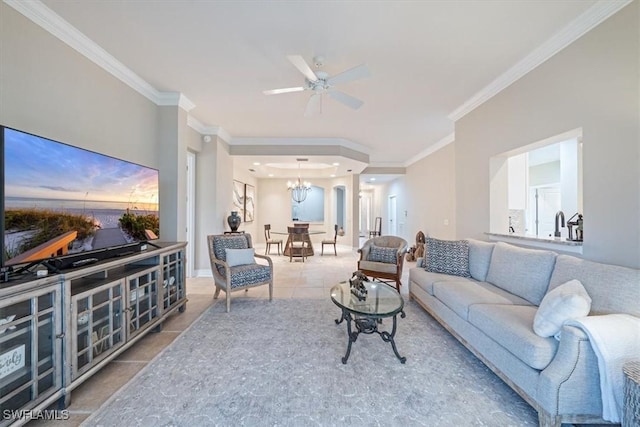 living room with ceiling fan with notable chandelier, light tile patterned flooring, and crown molding