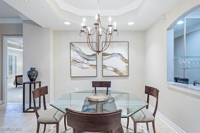 dining room featuring a tray ceiling, an inviting chandelier, and ornamental molding