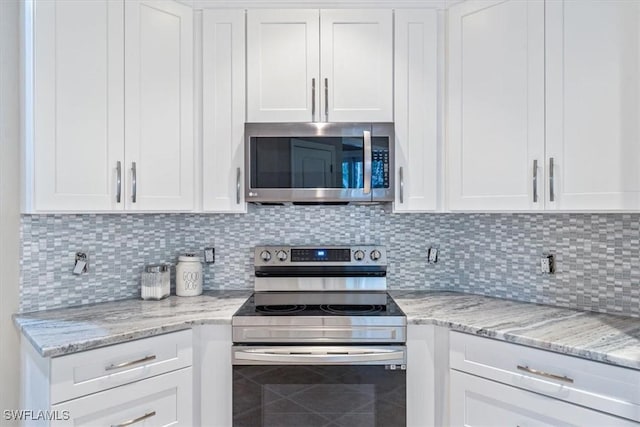 kitchen featuring backsplash, white cabinetry, and stainless steel appliances