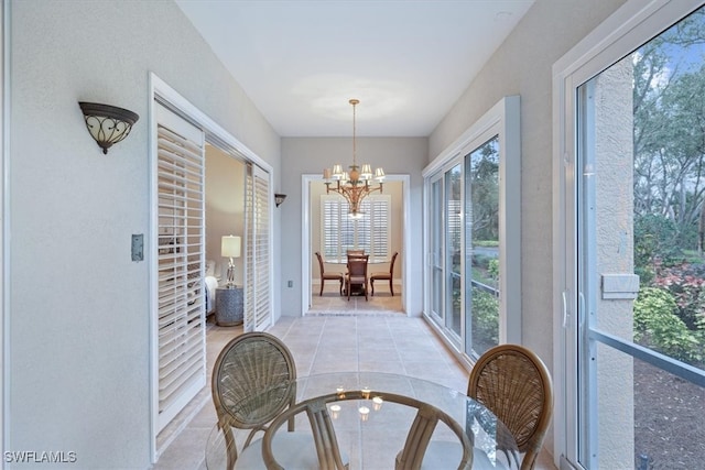 sunroom / solarium featuring a notable chandelier