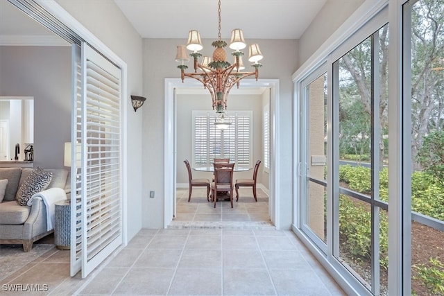 doorway to outside with light tile patterned floors, ornamental molding, and an inviting chandelier