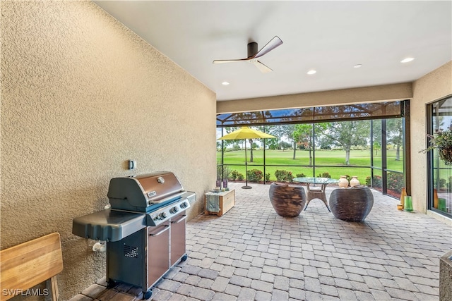 view of patio / terrace featuring glass enclosure, grilling area, and ceiling fan