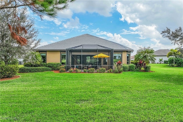 back of house featuring a lawn and a lanai