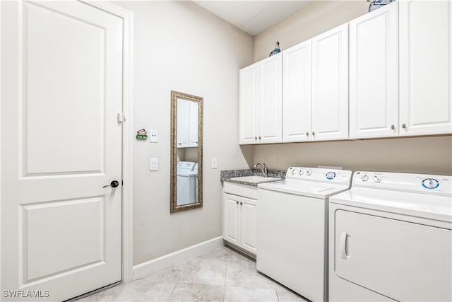 laundry area with washing machine and dryer, cabinets, sink, and light tile patterned floors