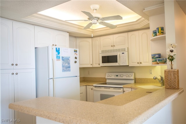 kitchen with white cabinetry, white appliances, a raised ceiling, sink, and kitchen peninsula