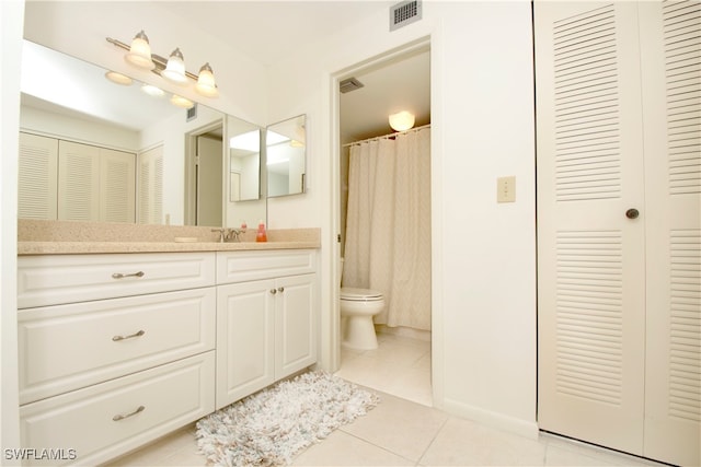 bathroom with tile patterned flooring, vanity, and toilet