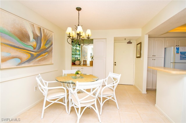 tiled dining area with a notable chandelier and a textured ceiling