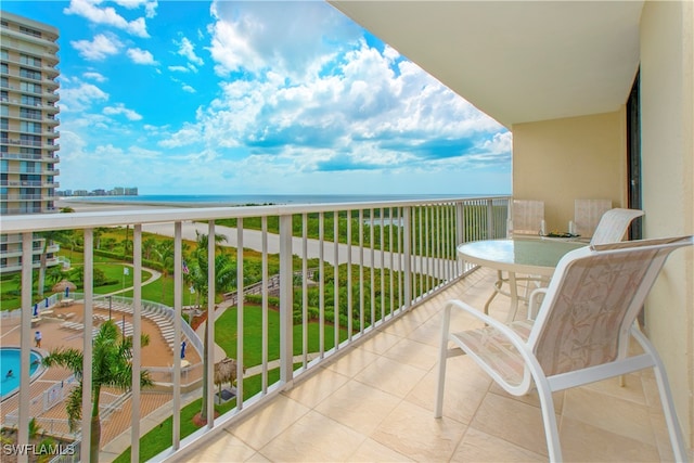 balcony featuring a view of the beach and a water view