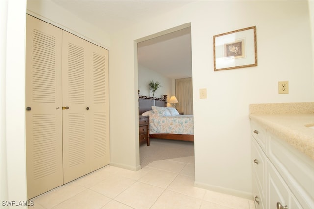 bedroom with light tile patterned floors and a closet