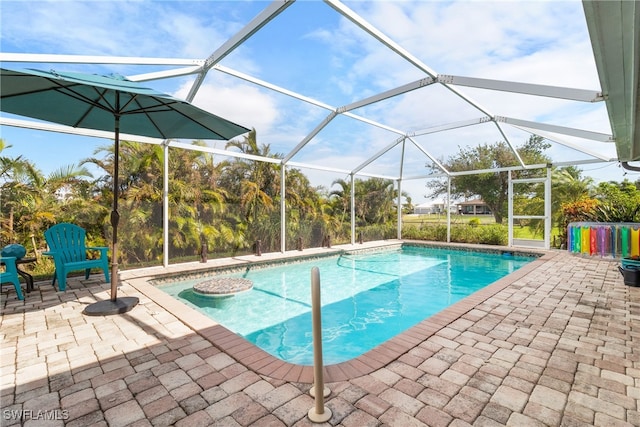 view of swimming pool with glass enclosure and a patio area